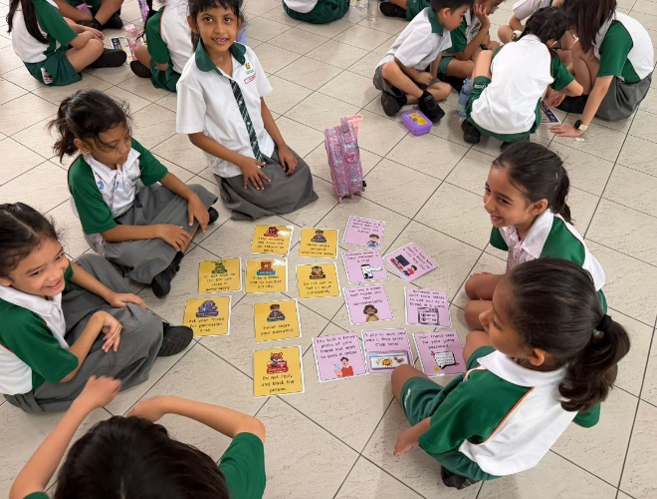 Students discussing cyber wellness topics using activity cards in small groups.